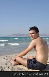 young man relaxing at Kos beach in Greece (blue sky)