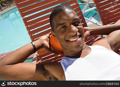 Young man relaxing by swimming pool portrait