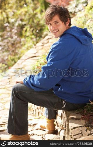 Young Man Relaxing In Autumn Garden