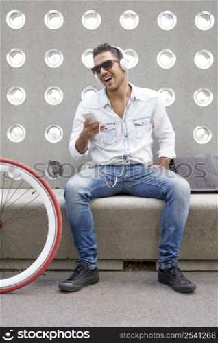 Young man relaxing on a bench while listening music( lifestyle )