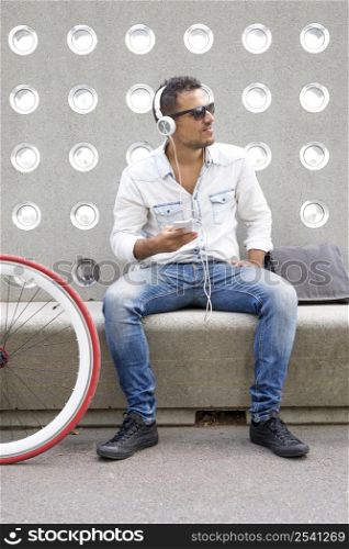 Young man relaxing on a bench while listening music( lifestyle )