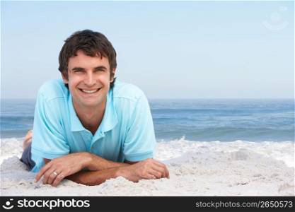 Young Man Relaxing On Sandy Beach