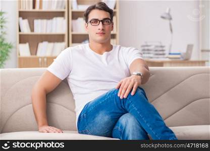 Young man relaxing sitting in couch sofa