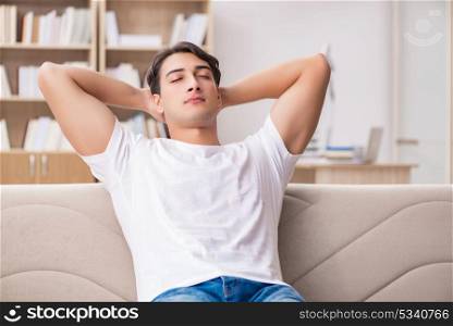 Young man relaxing sitting in couch sofa