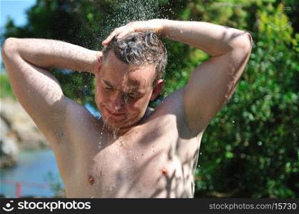 young man relaxing under shower