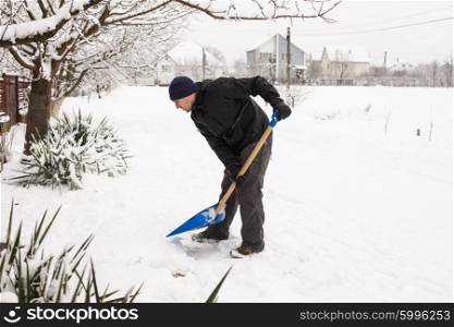 Young man remove snow near the suburban house. The Snow removal