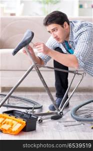 Young man repairing bicycle at home