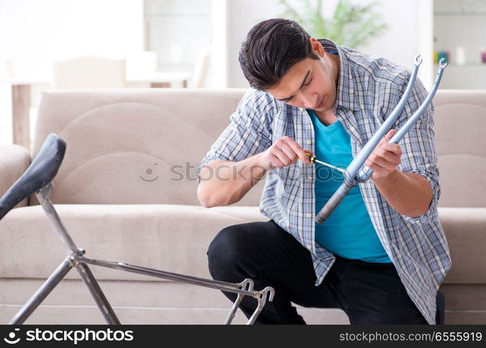 Young man repairing bicycle at home