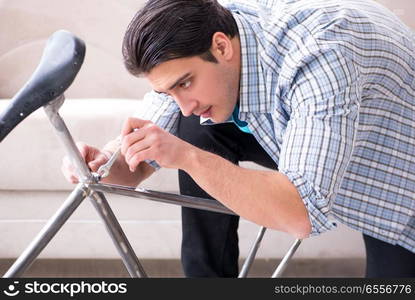 Young man repairing bicycle at home