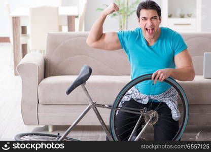 Young man repairing bicycle at home