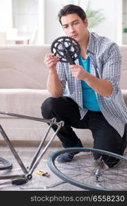 Young man repairing bicycle at home