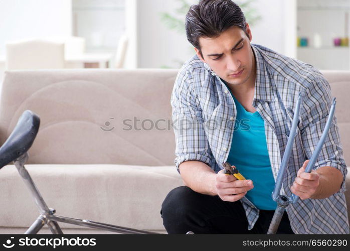 Young man repairing bicycle at home