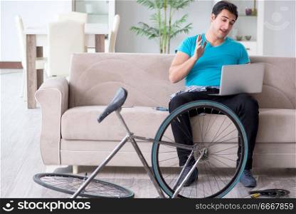 Young man repairing bicycle at home