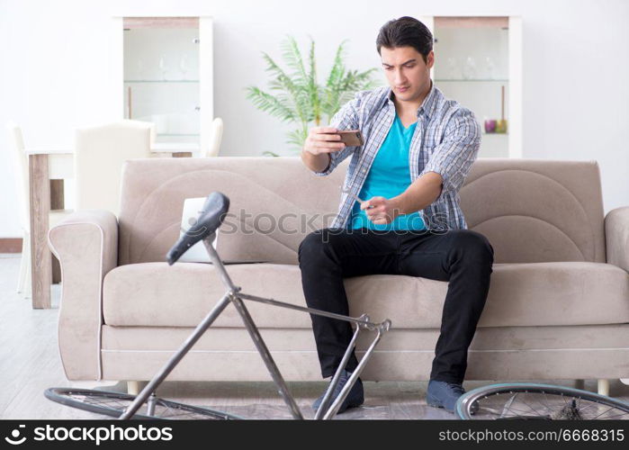 Young man repairing bicycle at home