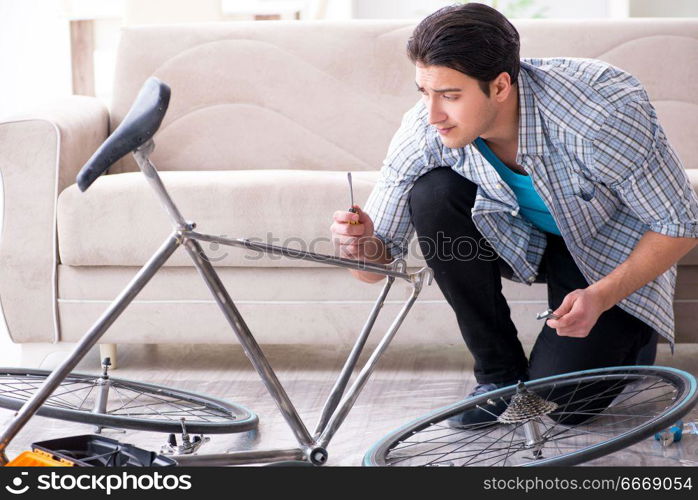 Young man repairing bicycle at home