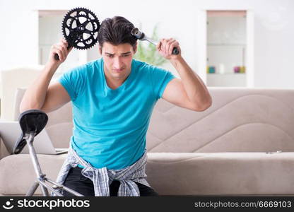 Young man repairing bicycle at home