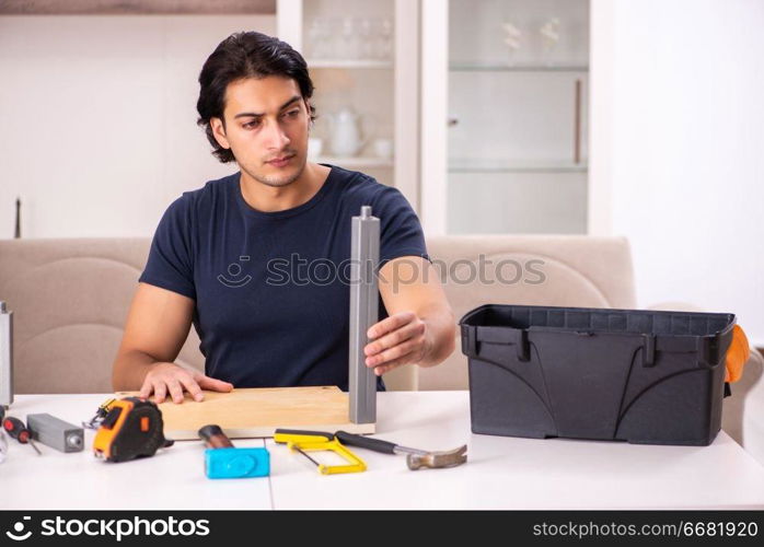 Young man repairing furniture at home 