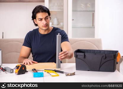 Young man repairing furniture at home 