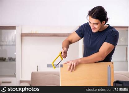 Young man repairing furniture at home 