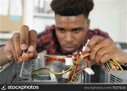 young man repairing motherboard from pc