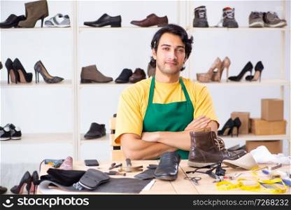 Young man repairing shoes in workshop 