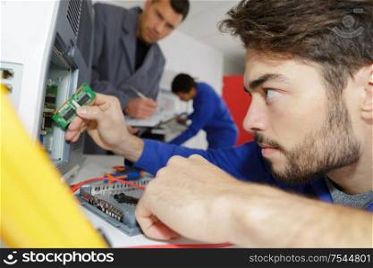young man repairs an electronic device