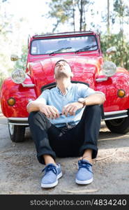 Young man resting at car trip by the countryside