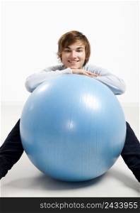 Young man resting over a pilates ball