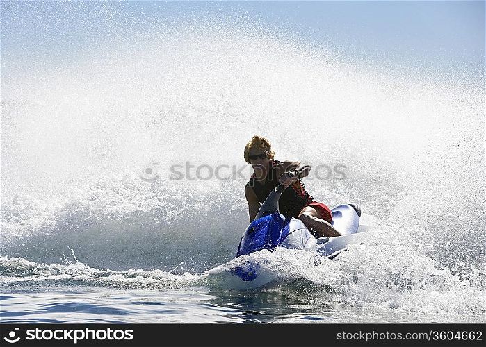 Young man riding jetski on lake