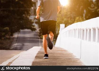Young man runner feet running on city bridge road be running for exercise. healthy exercise concept.