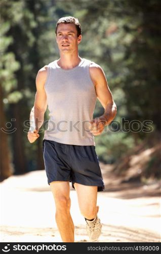 Young man running along country lane