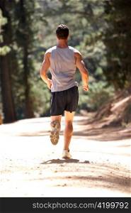 Young man running along country lane