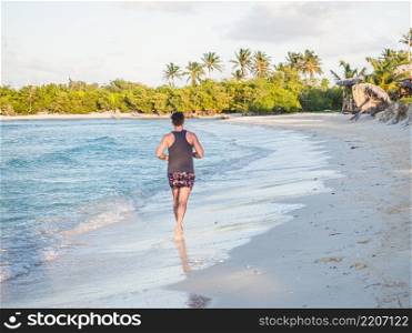 Young man running along the coast of the Atlantic Ocean. Close-up. Vacation and travel concept. Young man running along the coast of the Atlantic Ocean