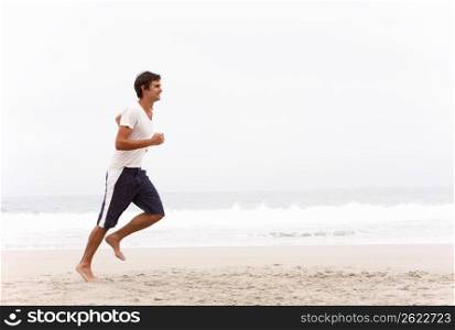 Young Man Running Along Winter Beach