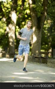 Young man running in the autumn park