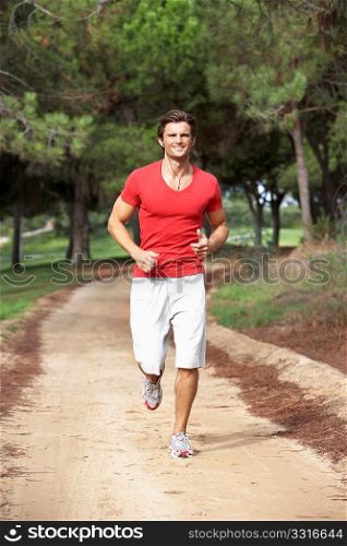 Young man running through park