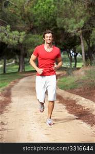 Young man running through park