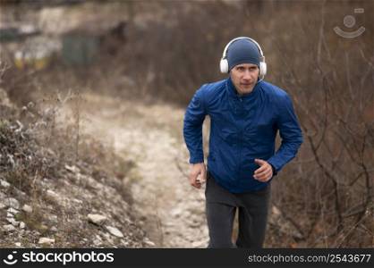 young man running trail nature