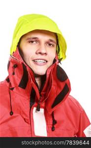 Young man sailor wearing red waterproof wind jacket and yellow hood isolated on white. Sailing yachting cruise. Studio shot.