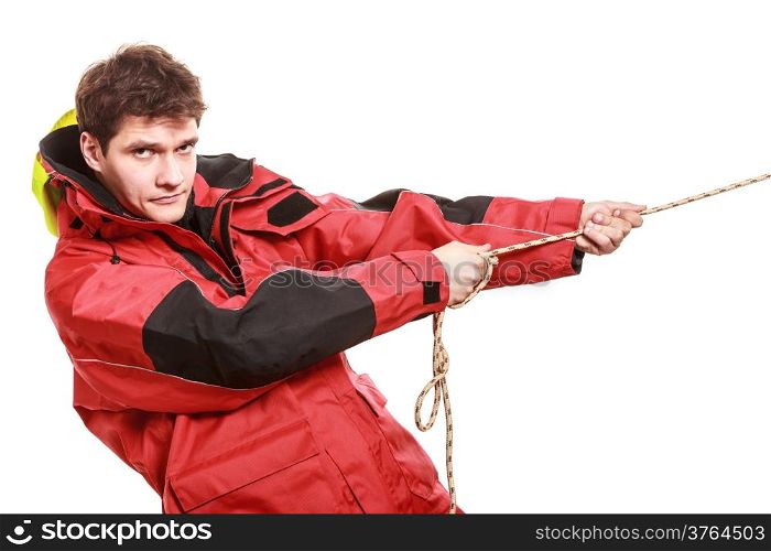 Young man sailor wearing red waterproof wind jacket pulling the rope isolated on white. Sailing yachting cruise. Studio shot.