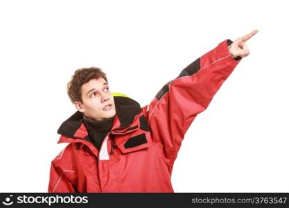 Young man sailor wearing red waterproof wind jacket showing pointing copy space blank isolated on white. Sailing yachting cruise. Studio shot.