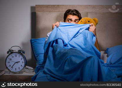 Young man scared in bed