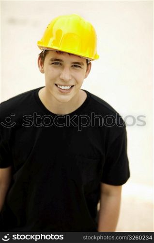young man, selective focus on eye, black t-shirt and yellow helmet great for your design oe text