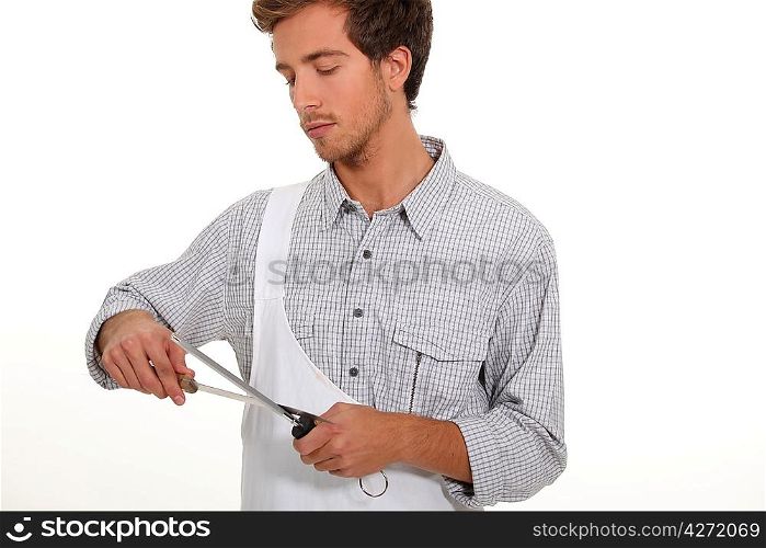 Young man sharpening knife