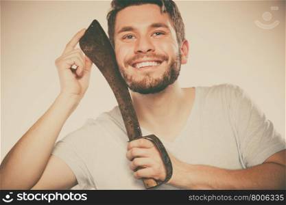 Young man shaving having fun with machete.. Young man with shaving having fun with machete large knife. Handsome guy removing face beard hair. Skin care and hygiene humor. Instagram filter.