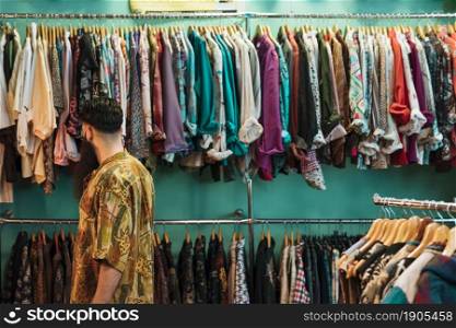 young man shirt choosing clothes mall clothing store. Beautiful photo. young man shirt choosing clothes mall clothing store