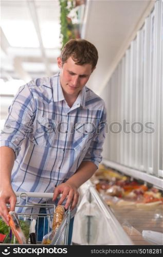 Young man shopping for frozen food in a grocery store