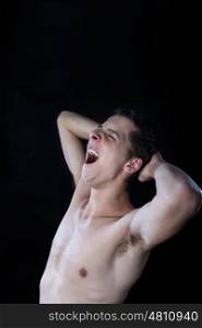 young man shouting at full lungs against black background