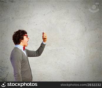 Young man shouting at his mobile phone
