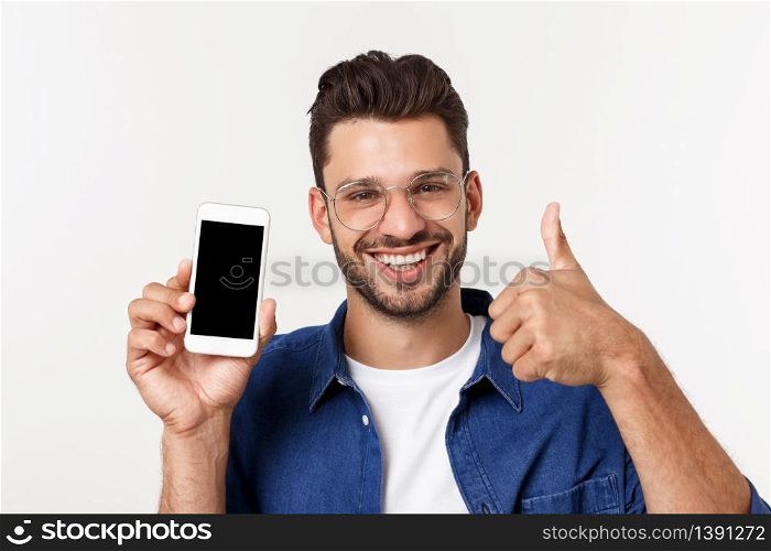 Young man showing a blank smart phone screen with thumbs up isolated on a white background. Young man showing a blank smart phone screen with thumbs up isolated on a white background.